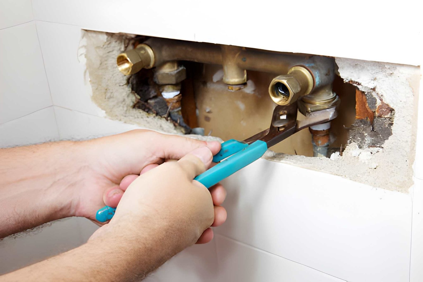 Plumber repairing a leaking bathtub valve behind a Knoxville bathroom wall
