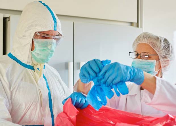 Technicians in protective suits handling biohazard cleanup