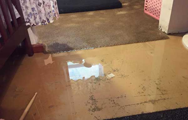 Standing floodwater covering a home floor after flood damage