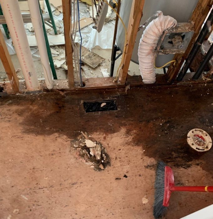 Flood Damaged Subfloor Wall Demolition East Tennessee Water-stained subfloor and opened wall cavity after flood damage cleanup and demolition in an East Tennessee home