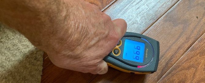 Moisture Meter Hardwood Floor Flood Damage Knoxville Technician checking a flooded hardwood floor with a moisture meter during flood damage cleanup in Knoxville, TN